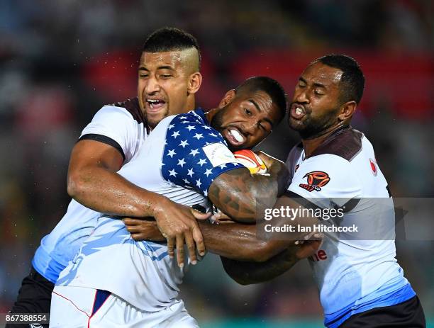 Eddy Pettybourne of the USA is tackled by Henry Raiwalui and Viliame Kikau of Fiji during the 2017 Rugby League World Cup match between Fiji and the...