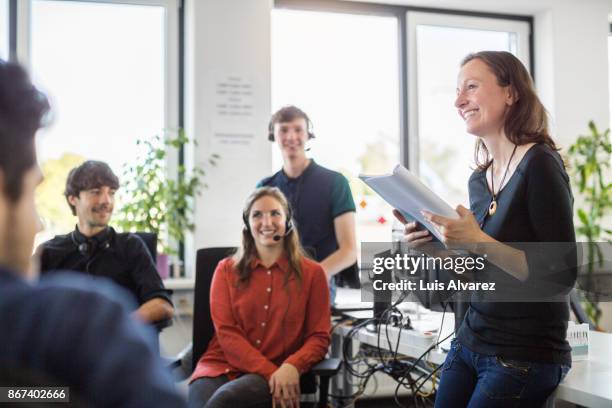 smiling businesswoman discussing with colleagues in meeting - call center team stock pictures, royalty-free photos & images