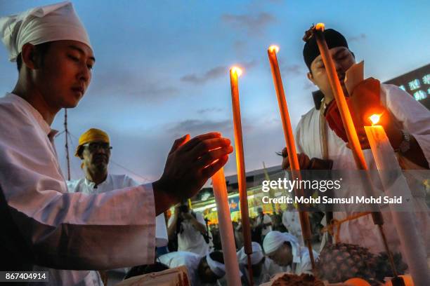 Malaysians of Chinese performs a specials prayer during the last day of Chinese Nine Emperor Gods Festival inside the temple on October 28, 2017 in...