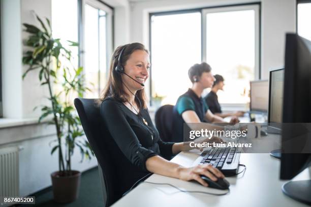 smiling customer service representative using computer - headset imagens e fotografias de stock