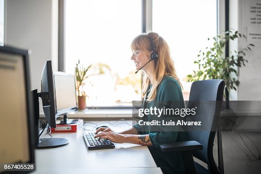 Side view of customer service representative using computer Side view of customer service representative using computer