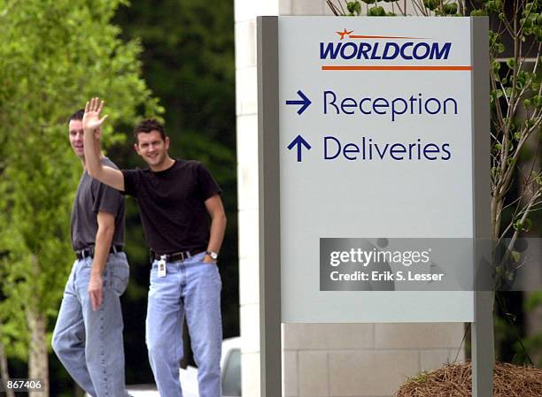 An employee waves to the media while leaving a WorldCom building June 28, 2002 in Alpharetta, Georgia. About 17,000 workers at the financially...