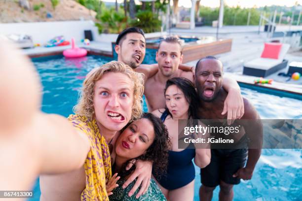 jonge groep vrienden op vakantie een selfie te nemen bij het zwembad - een gek gezicht trekken stockfoto's en -beelden