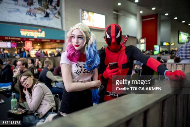 Cosplayers dressed as Harley Quinn and Deadpool attend the MCM Comic Con at ExCeL exhibition centre in London on October 28, 2017. / AFP PHOTO /...