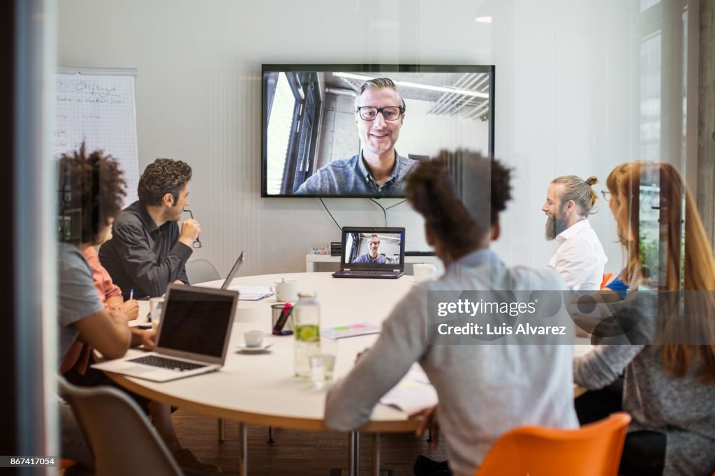 Business people having video conference meeting in board room
