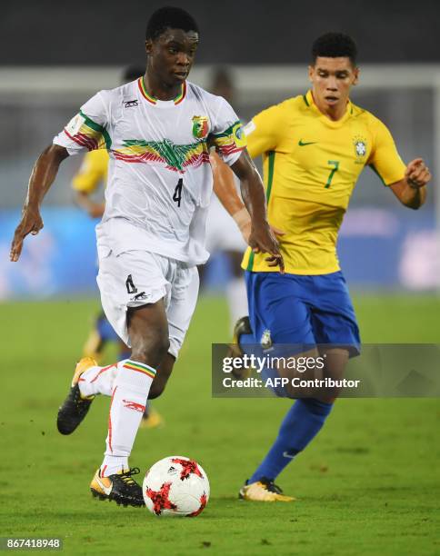 Paulinho of Brazil fights for the ball with Fode Konate of Mali during their third place FIFA U-17 World Cup football match at the Vivekananda Yuba...