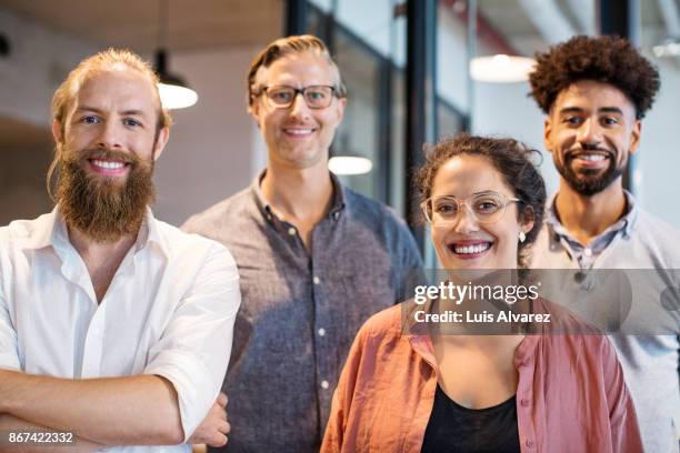 team of business people smiling in creative office - four people stock-fotos und bilder