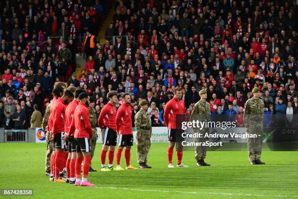 Lincoln City players are joined by military personnel during a minutes silence as part of Remembrance Day commemorations prior to the Sky Bet League...