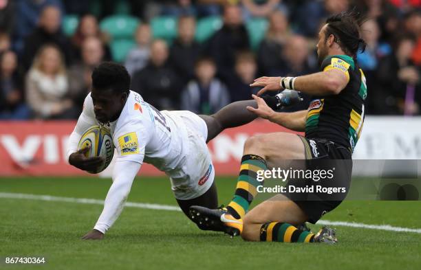 Christian Wade of Wasps dives over for their first try despite being held by Ben Foden during the Aviva Premiership match between Northampton Saints...