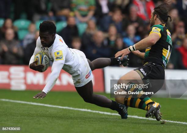 Christian Wade of Wasps dives over for their first try despite being held by Ben Foden during the Aviva Premiership match between Northampton Saints...