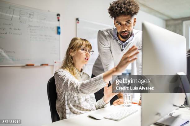 businesswoman and businessman discussing over computer in office - explain stock-fotos und bilder