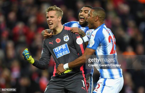 Jonas Lossl of Huddersfield Town celebrates saving a penalty with Danny Williams of Huddersfield Town and Mathias Jorgensen of Huddersfield Town...