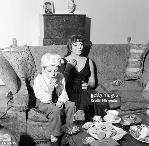 Joan Collins, actress, aged 22, pictured wearing black silk cocktail dress, at her flat in Marylebone, London, 10th February 1954. Photo-call after...