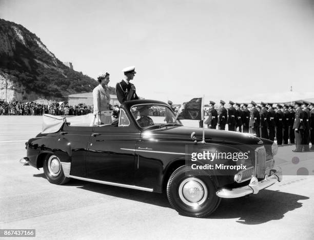 Queen Elizabeth II and the Duke of Edinburgh in an open car reviewing troops on a visit to Gibraltar, this was their last port of call of this Royal...