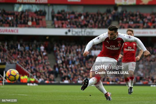 Arsenal's German-born Bosnian defender Sead Kolasinac shoots to score their first goal during the English Premier League football match between...