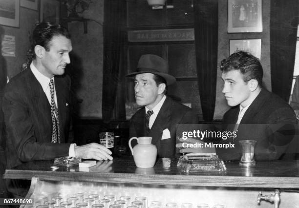 Cross-counter view of Eddie Chapman , Billy Hill , and George Walker discussing the mystery of the Flamingo in London yesterday, 1st August 1954.