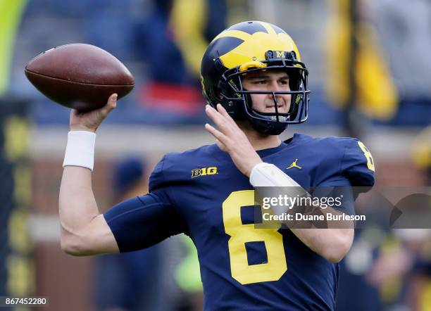 Quarterback John O'Korn of the Michigan Wolverines passes the ball while warming up for a game against the Rutgers Scarlet Knights at Michigan...