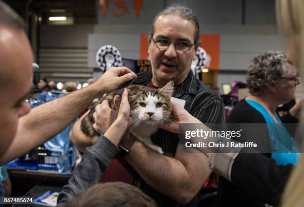 Man holds his cat as members of the public pet it during the Supreme Cat Show on October 28, 2017 in Birmingham, England. The one-day Supreme Cat...