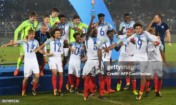 England's players celebrate after winning the final FIFA U-17 World Cup football match against Spain at the Vivekananda Yuba Bharati Krirangan...