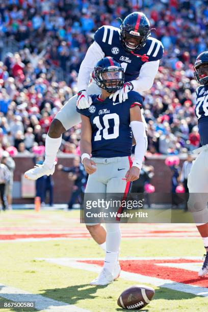 Brown jumps on the back of Jordan Ta'amu of the Ole Miss Rebels in celebration after a touchdown in the first half past of a game the Arkansas...