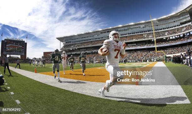 Shane Buechele of the Texas Longhorns runs through the end zone scoring a touchdown as Jameson Houston and Verkedric Vaughns of the Baylor Bears...