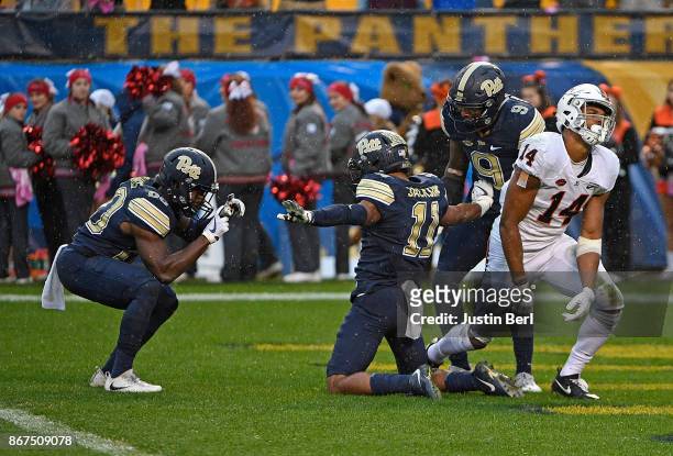 Dane Jackson of the Pittsburgh Panthers reacts with teammates after breaking up a pass intended for Andre Levrone of the Virginia Cavaliers in the...