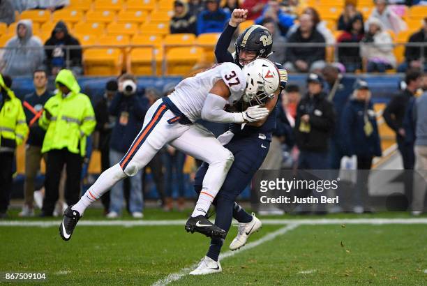 Jordan Mack of the Virginia Cavaliers hits Ben Dinucci of the Pittsburgh Panthers after a throw in the first half during the game at Heinz Field on...