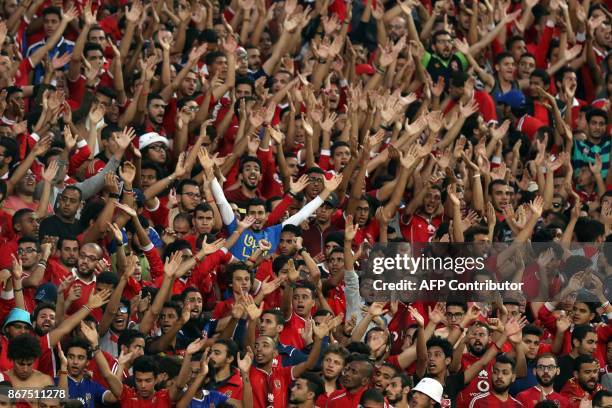 Al-Ahly supporters cheer for their team during the CAF Champions League final football match between Al-Ahly vs Wydad Casablanca at the Borg El Arab...