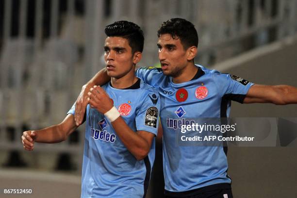 Wydad's striker Achraf Bencharki celebrates his equalising goal with his teammate during the CAF Champions League final football match between...