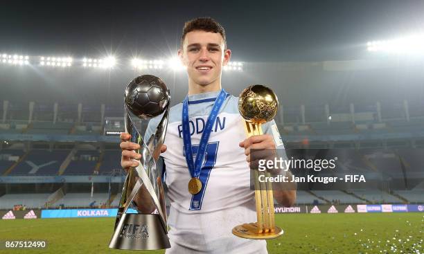 Philip Foden of England poses with the winners trophy and best young player trophy during the FIFA U-17 World Cup India 2017 Final match between...