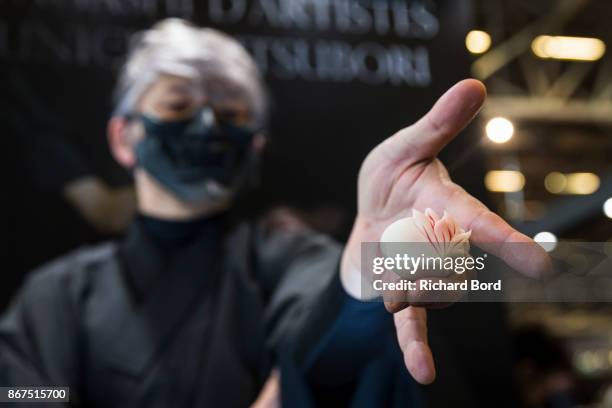 Wagashi artist Junichi Mitsubori poses with a traditional sweet during chocolate fair 'Salon Du Chocolat' at Parc des Expositions Porte de Versailles...