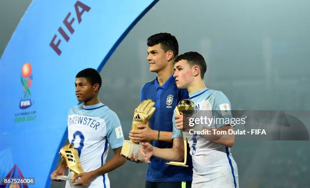 Phil Foden with his 'Man of the Tournament' trophy, Rhin Brewster with his 'Highest Scorer' trophy of England and goalkeeper Gabriel Brazao with his...