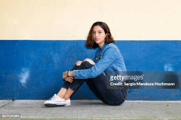 One hispanic teenage girl sitting on the floor in Mexico City, Mexico