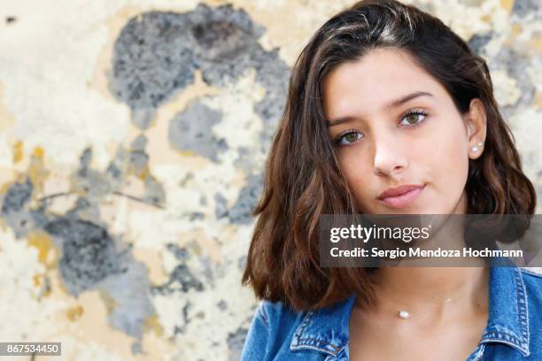 one hispanic teenage girl posing in front of a weathered wall in mexico city, mexico - green eyes stock pictures, royalty-free photos & images