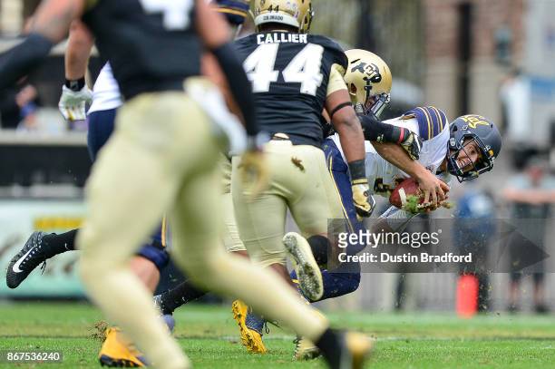Quarterback Ross Bowers of the California Golden Bears is sacked by linebacker Drew Lewis of the Colorado Buffaloes in the second quarter of a game...