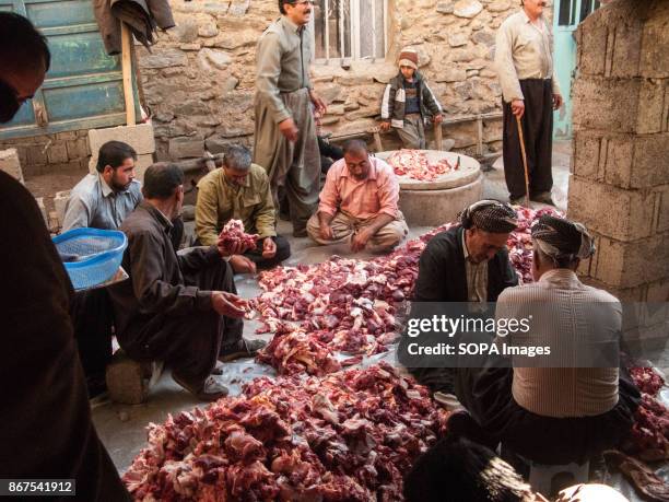 People seen volunteering to prepare the festival meat to be distributed between locals. Eid-e qorban is a Islamic annals traditional festival to...