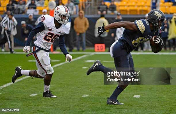 Jester Weah of the Pittsburgh Panthers runs up field past Brenton Nelson of the Virginia Cavaliers after a catch for a 19 yard touchdown reception in...