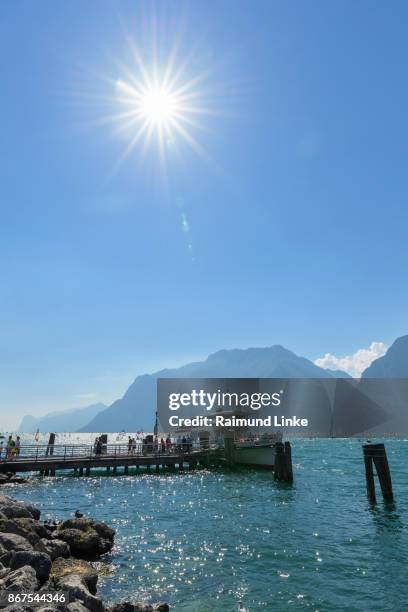 pier with excursion ship and sun, torbole, lake garda, lago di garda, trentino, italy - torbole stock pictures, royalty-free photos & images