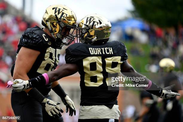 Wide receiver Greg Dortch celebrates with tight end Cam Serigne of the Wake Forest Demon Deacons after scoring a touchdown against the Louisville...