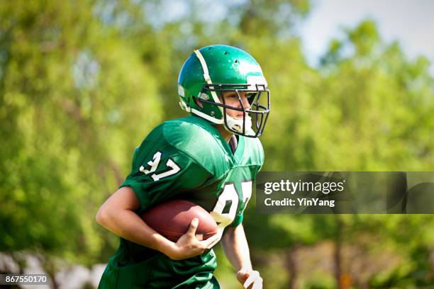 high school  or university american football player playing in field - secondary school sport stock pictures, royalty-free photos & images