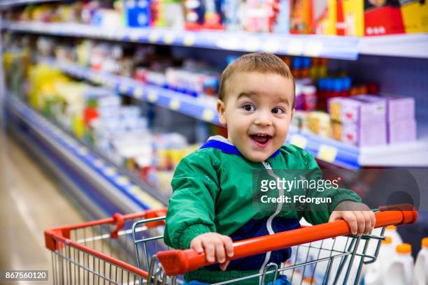 スーパーでショッピングカートに座っている男の子の赤ちゃん - baby products ストックフォトと画像
