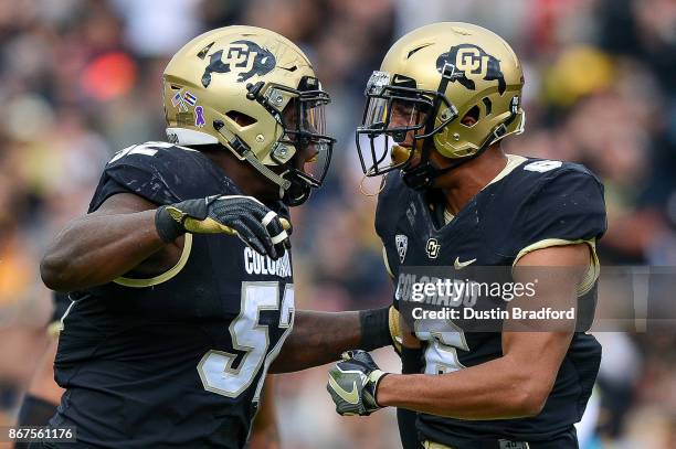 Defensive end Leo Jackson III and defensive back Evan Worthington of the Colorado Buffaloes celebrate a defensive play against the California Golden...