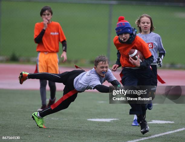 Zach Rivers runs up field after making an interception, The CFL-NFL are hosting a flag football regional tournament featuring co-ed teams of 10-11...