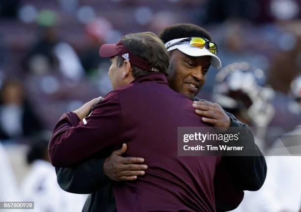 Head coach Kevin Sumlin of the Texas A&M Aggies meets with head coach Dan Mullen of the Mississippi State Bulldogs prior to the game at Kyle Field on...