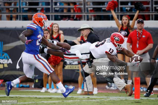 Elijah Holyfield of the Georgia Bulldogs dives into the end zone for a 39-yard touchdown in the fourth quarter of a game against the Florida Gators...