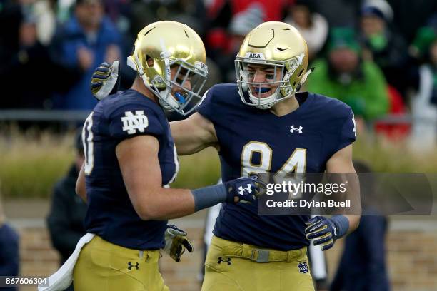 Durham Smythe and Cole Kmet of the Notre Dame Fighting Irish celebrate after scoring a touchdown in the first quarter against the North Carolina...