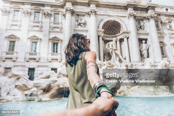 mujer joven divertirse frente a fontana de trevi - seguir actividad móvil general fotografías e imágenes de stock