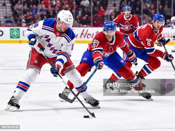 Miller of the New York Rangers skates the puck against Max Pacioretty of the Montreal Canadiens during the NHL game at the Bell Centre on October 28,...