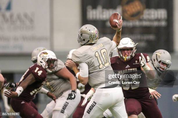 Quarterback Matt Linehan of the Idaho Vandals throws a pass in the face of pressure by defensive lineman Mason Husmann of the Louisiana Monroe...