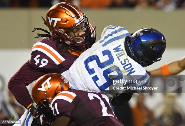 Linebacker Tremaine Edmunds and safety Reggie Floyd of the Virginia Tech Hokies tackle running back Shaun Wilson of the Duke Blue Devils in the first...